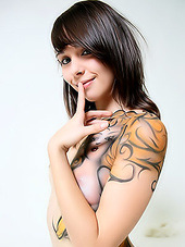 Innocent looking teen exposing her tattooed wild